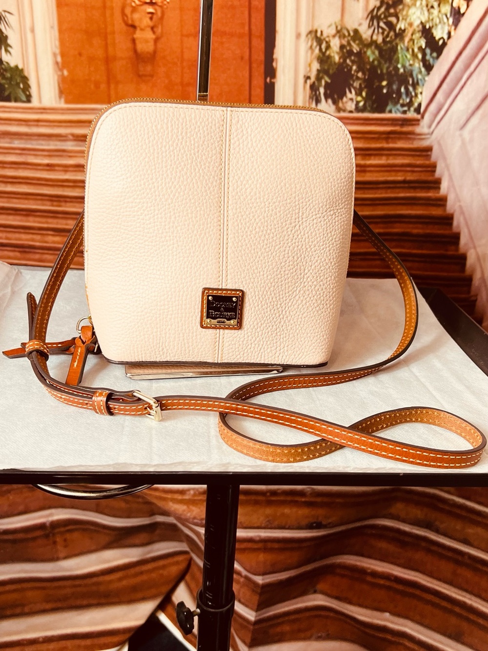 Dooney & Bourke Trixie crossbody bag is crafted from ballet pink pebble leather